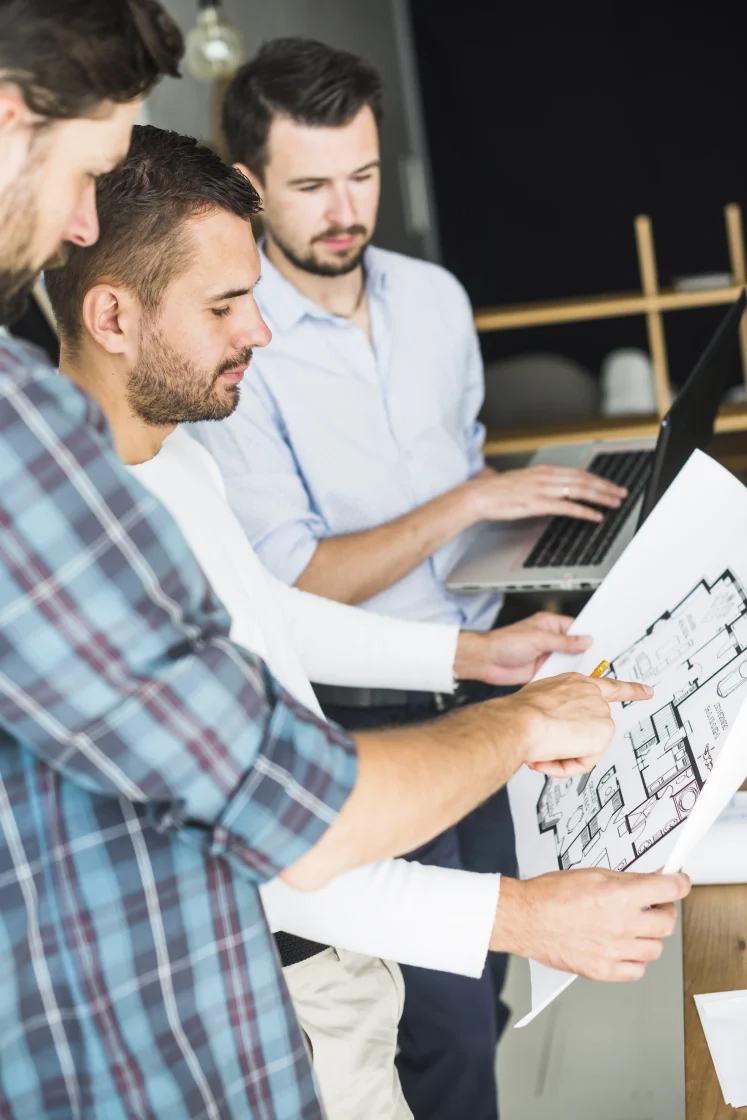 group male architect having discussion blueprint scaled